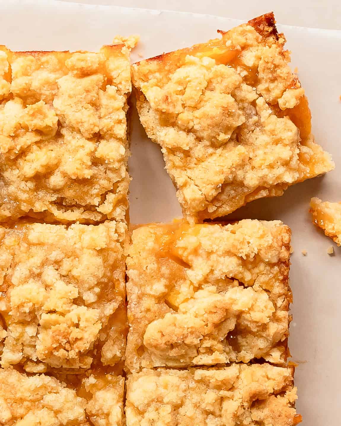 Close-up of peach crumble bars made with fresh peaches and a golden streusel topping.