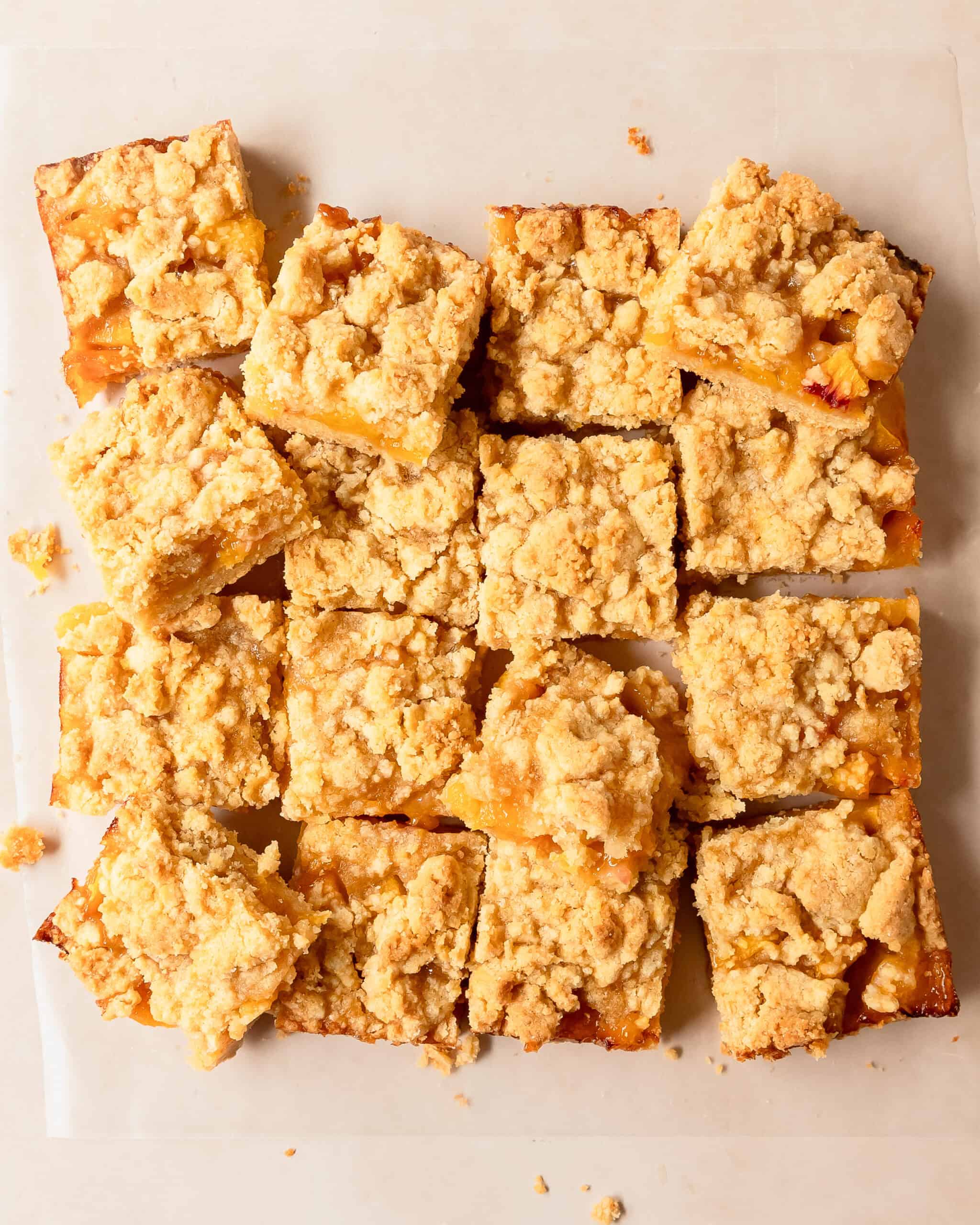 Slice of peach bars showing layers of crust, juicy peach filling, and crumb topping.