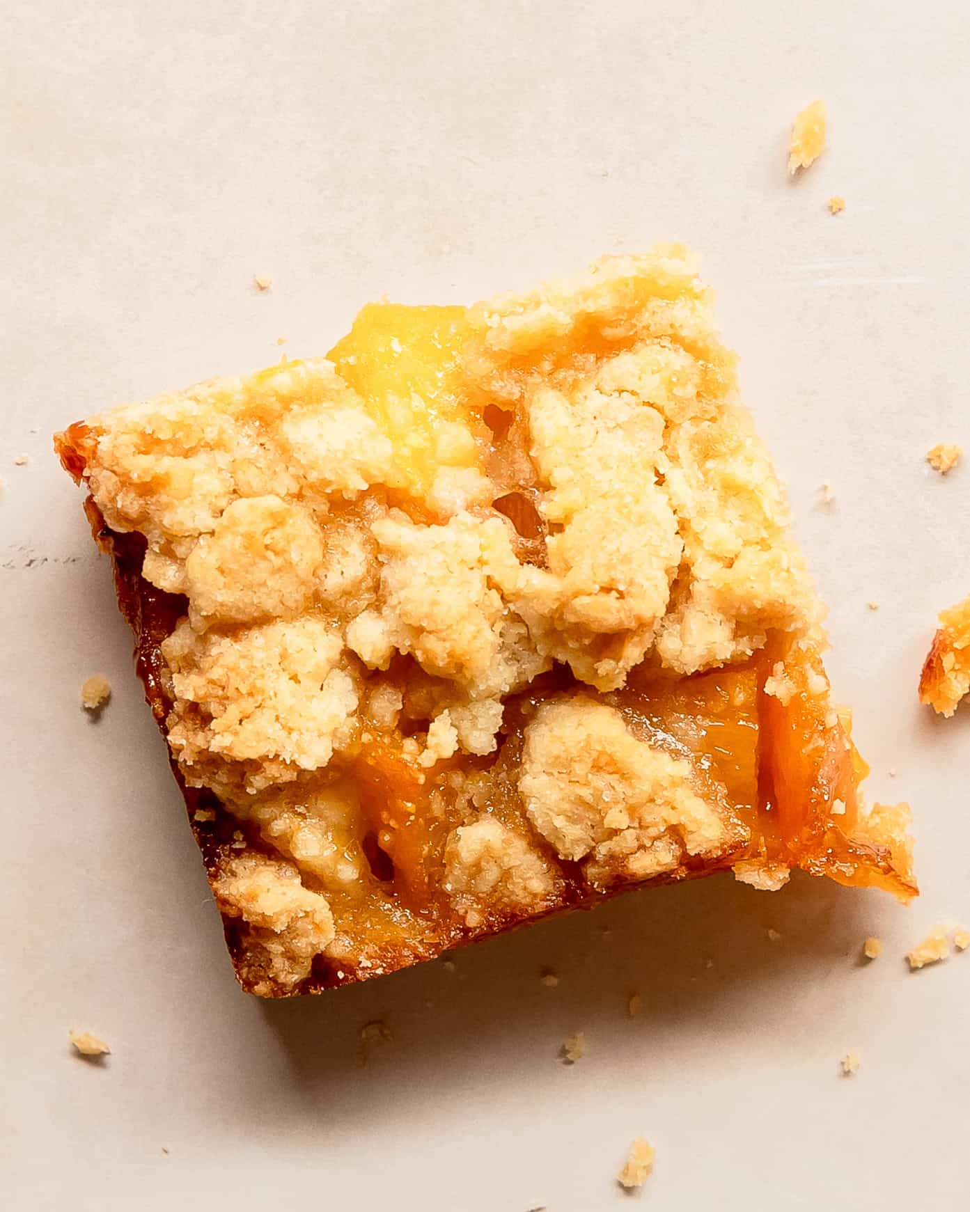 Close-up of a slice of peach crumble bars made with fresh peaches and a buttery, golden streusel topping.