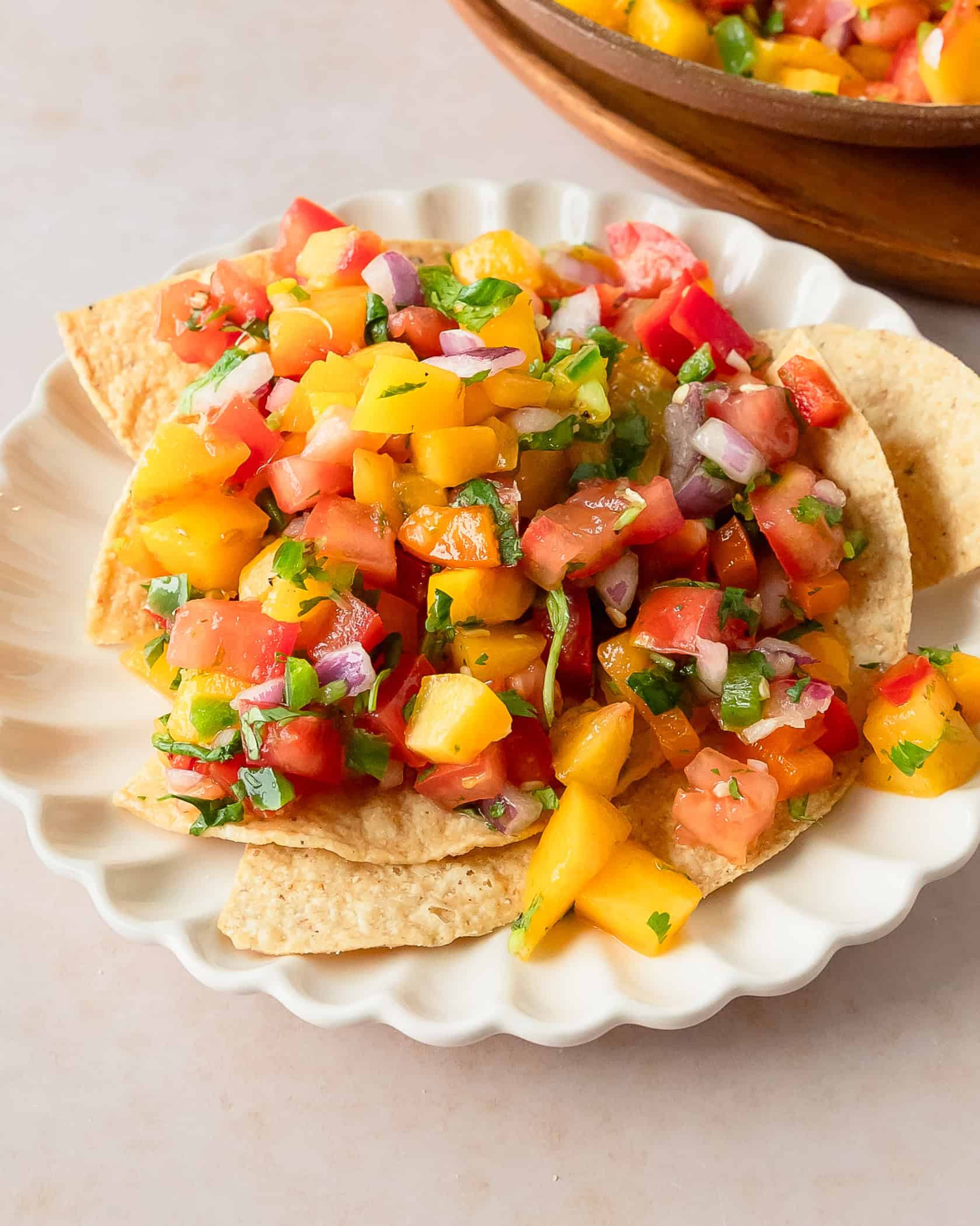 Sweet and spicy peach salsa in a white bowl, perfect for summer appetizers and snacks.