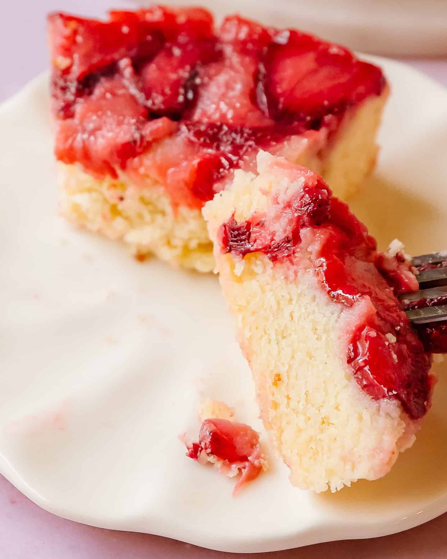 Close-up slice of strawberry upside down cake with soft buttery crumb.