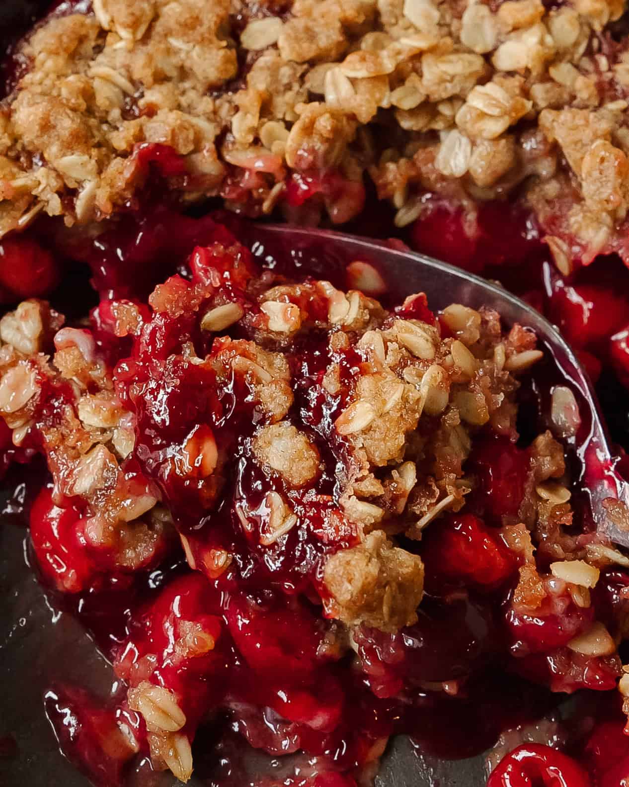 Close-up of cherry crisp showing juicy cherry filling and crisp oat crumble.