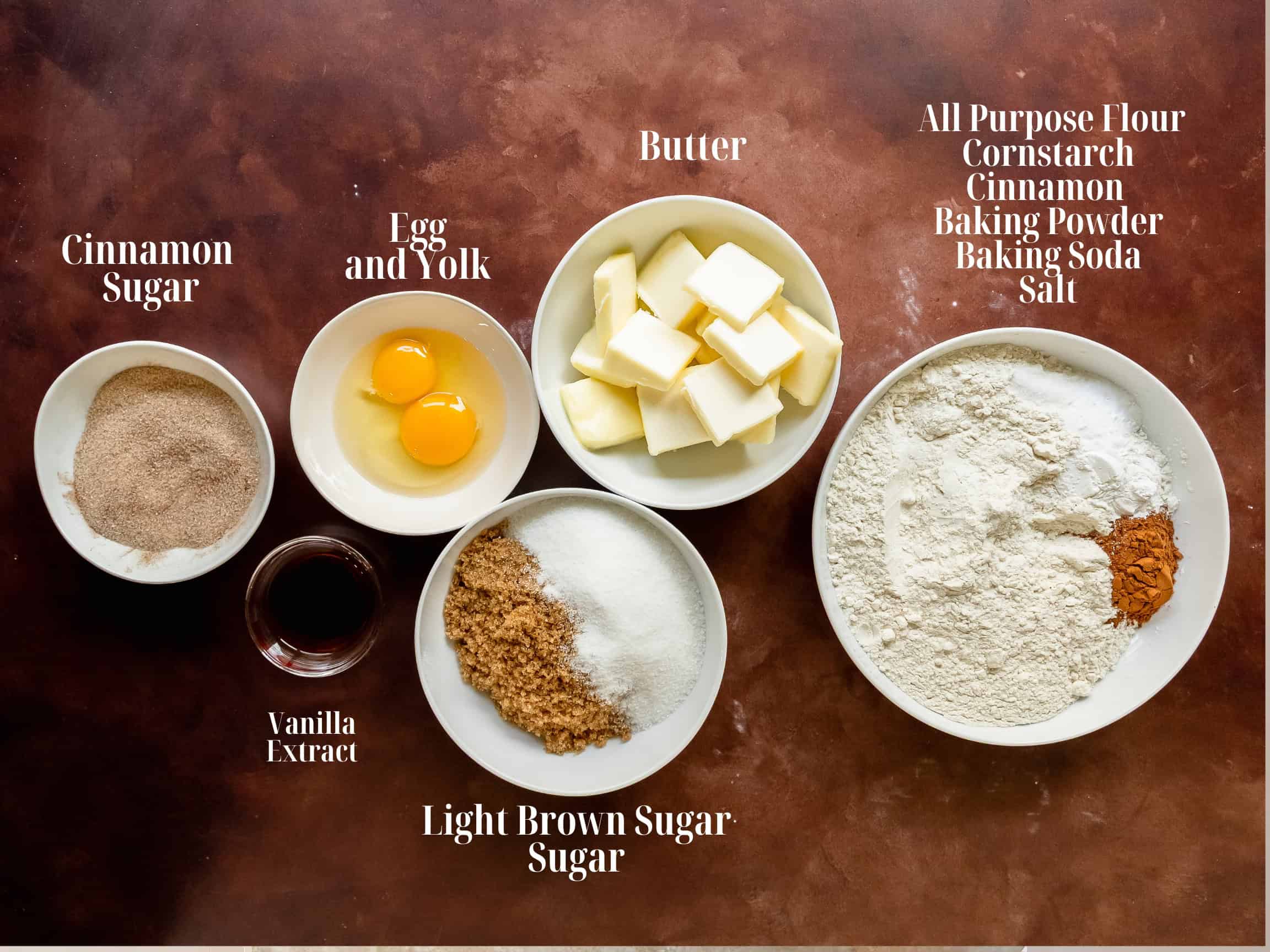 Ingredients to make cinnamon cookies in white bowls.