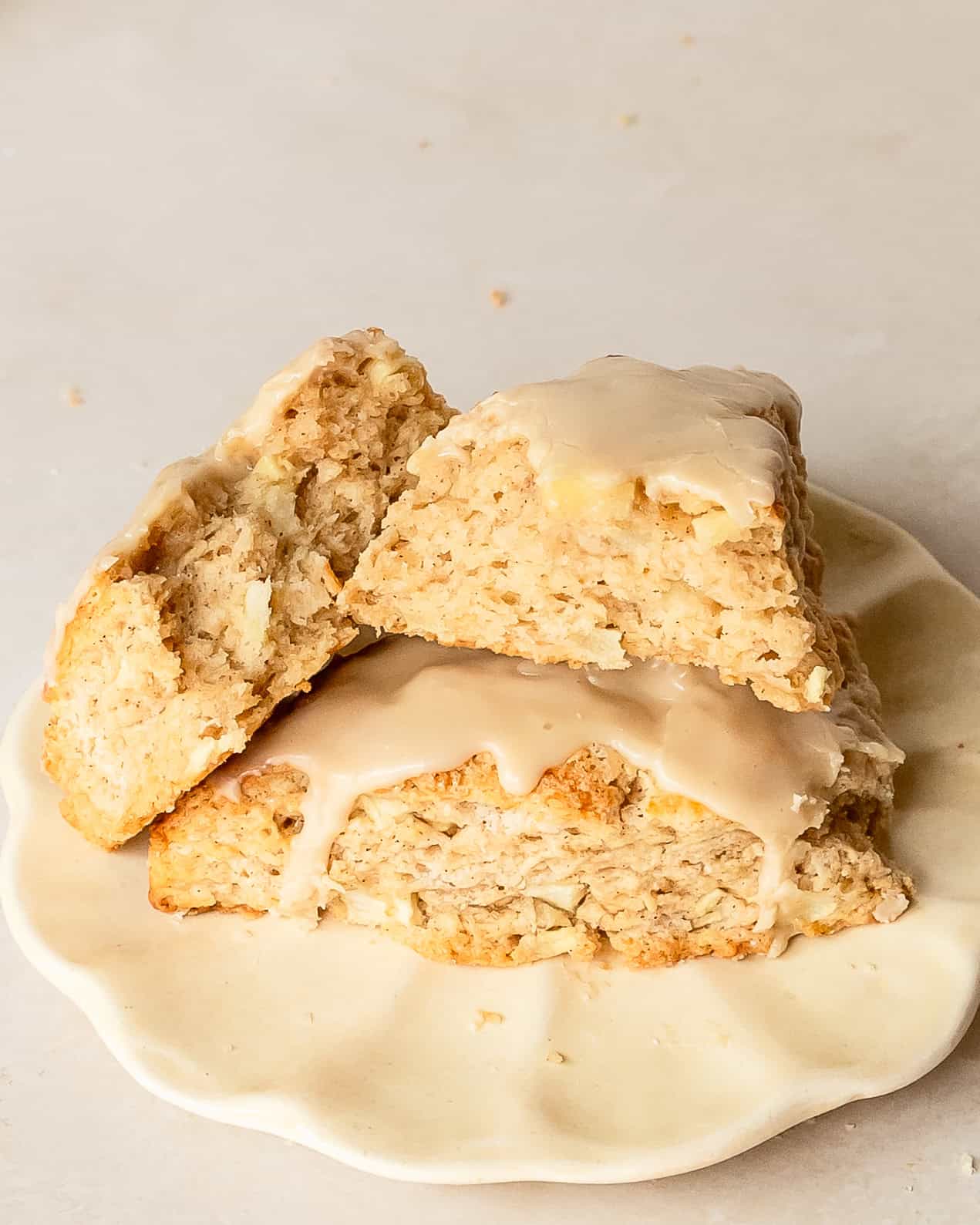 Tender apple scone showing its soft, flaky texture and creamy maple glaze.