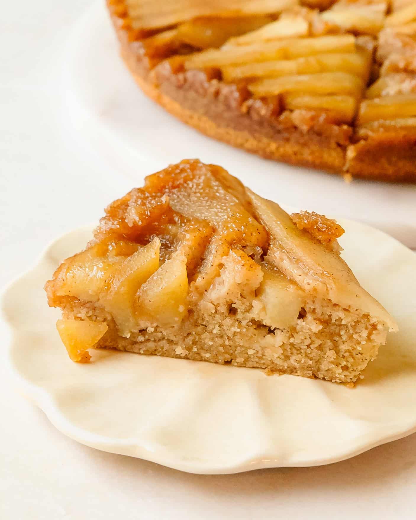 Homemade apple upside down cake slice with a golden caramelized apple topping and fluffy spiced cake.