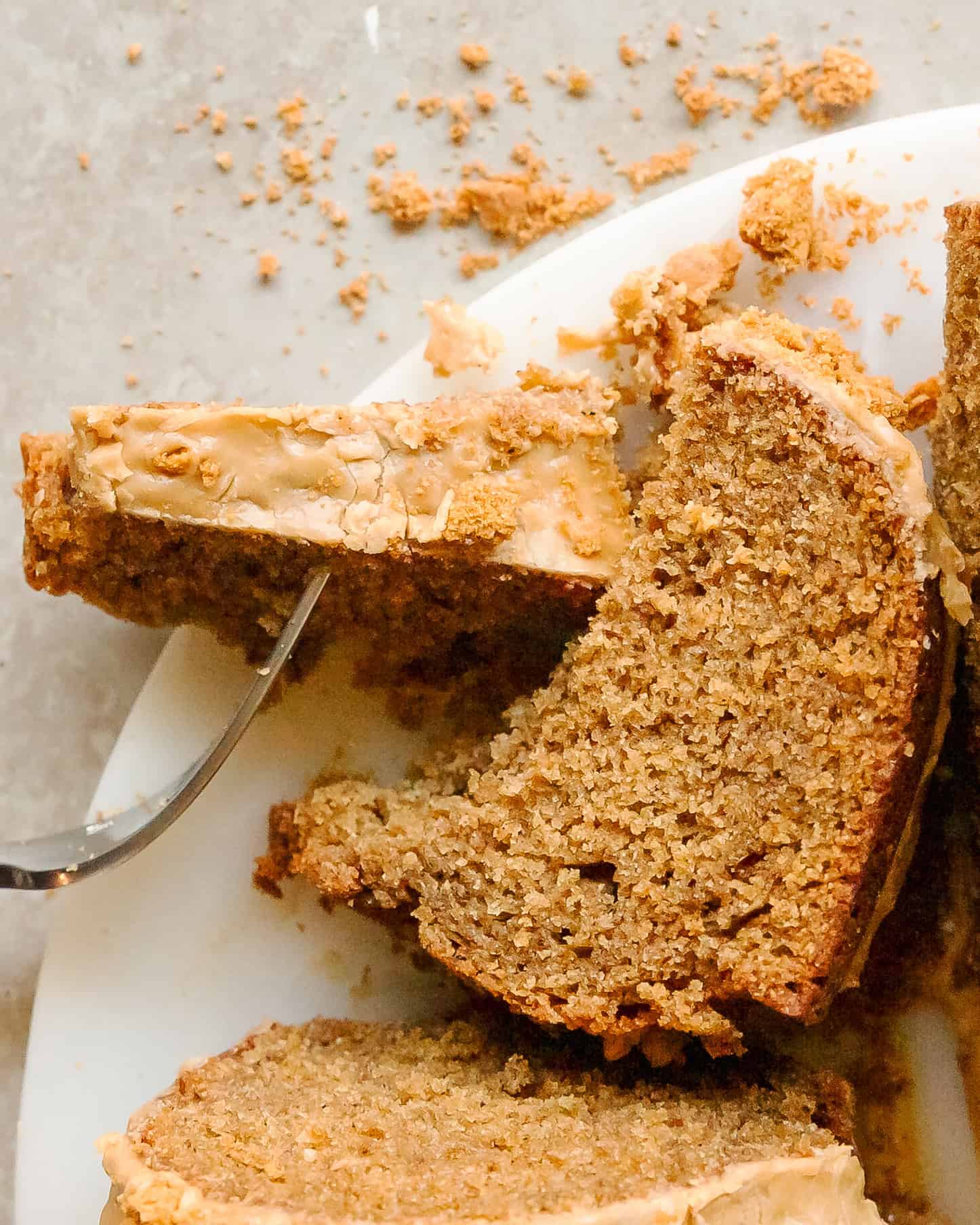Biscoff Bundt Cake slice showing the golden cake interior with glaze dripping down the sides.