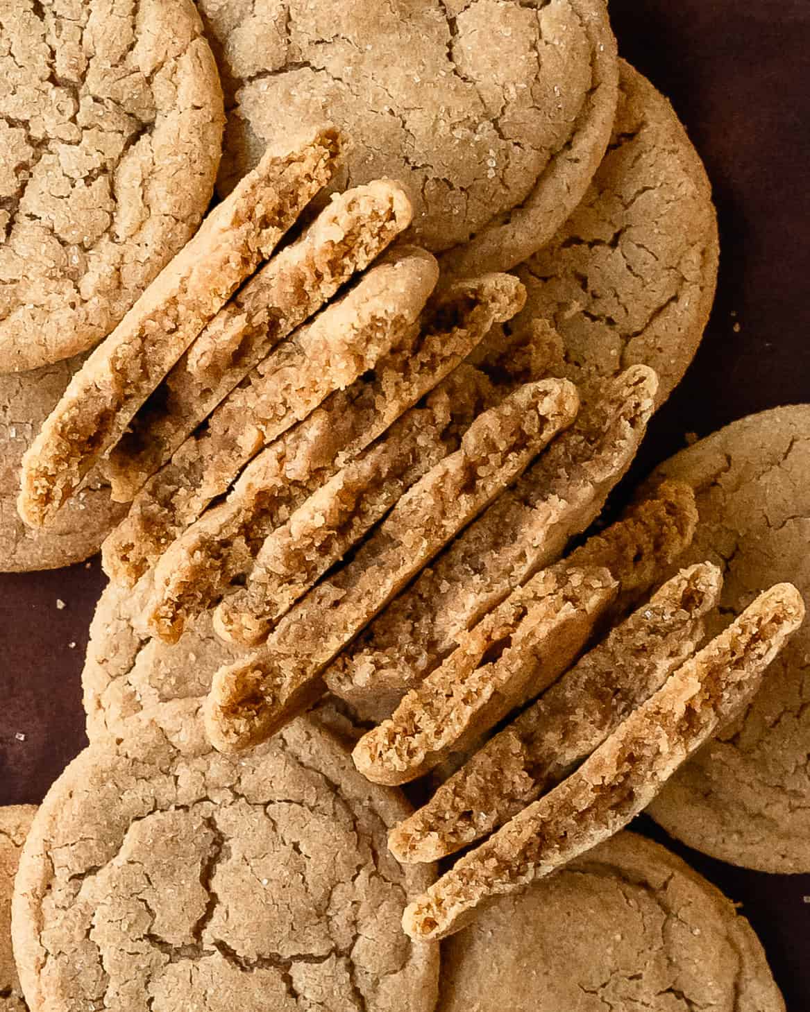 A stack of cinnamon sugar cookies broken in half showing its soft, tender centers.