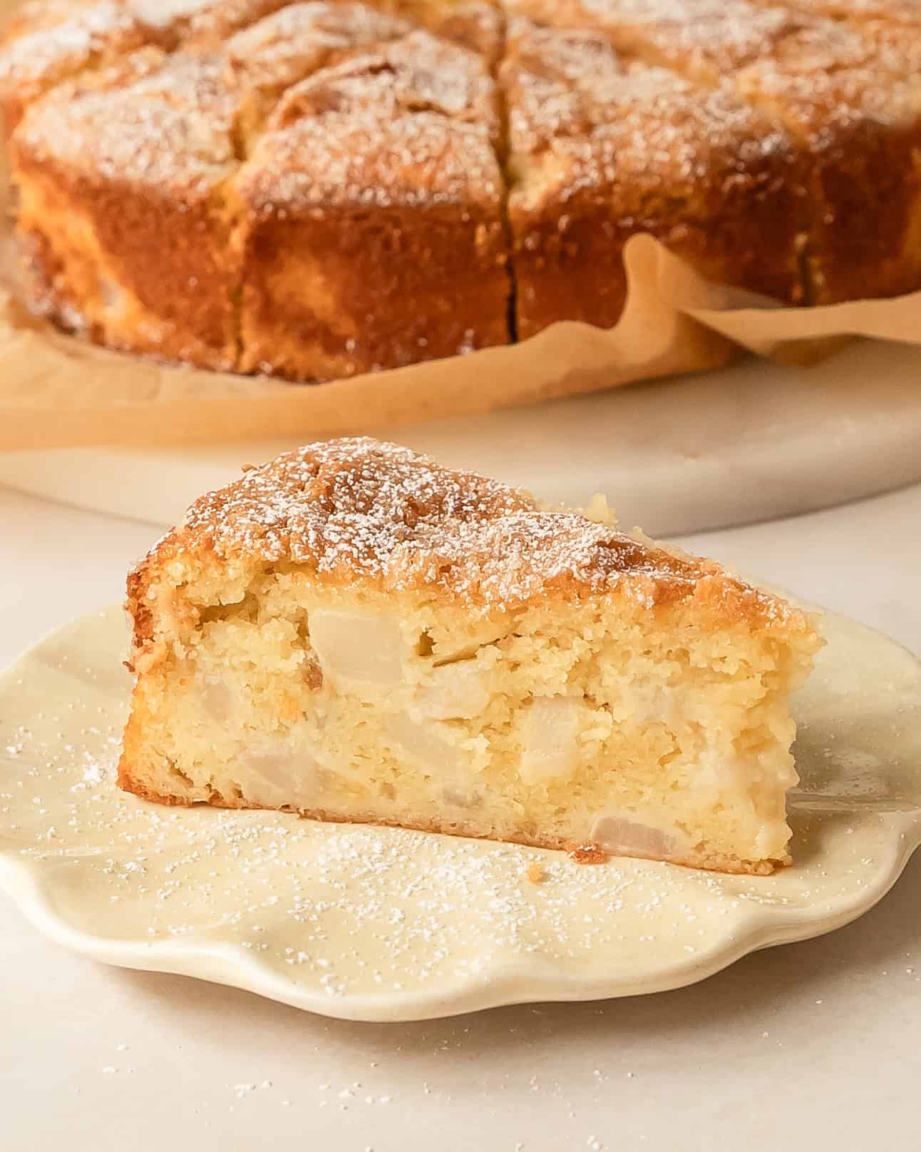 Slice of French pear cake showing the tender crumb and fresh pears.