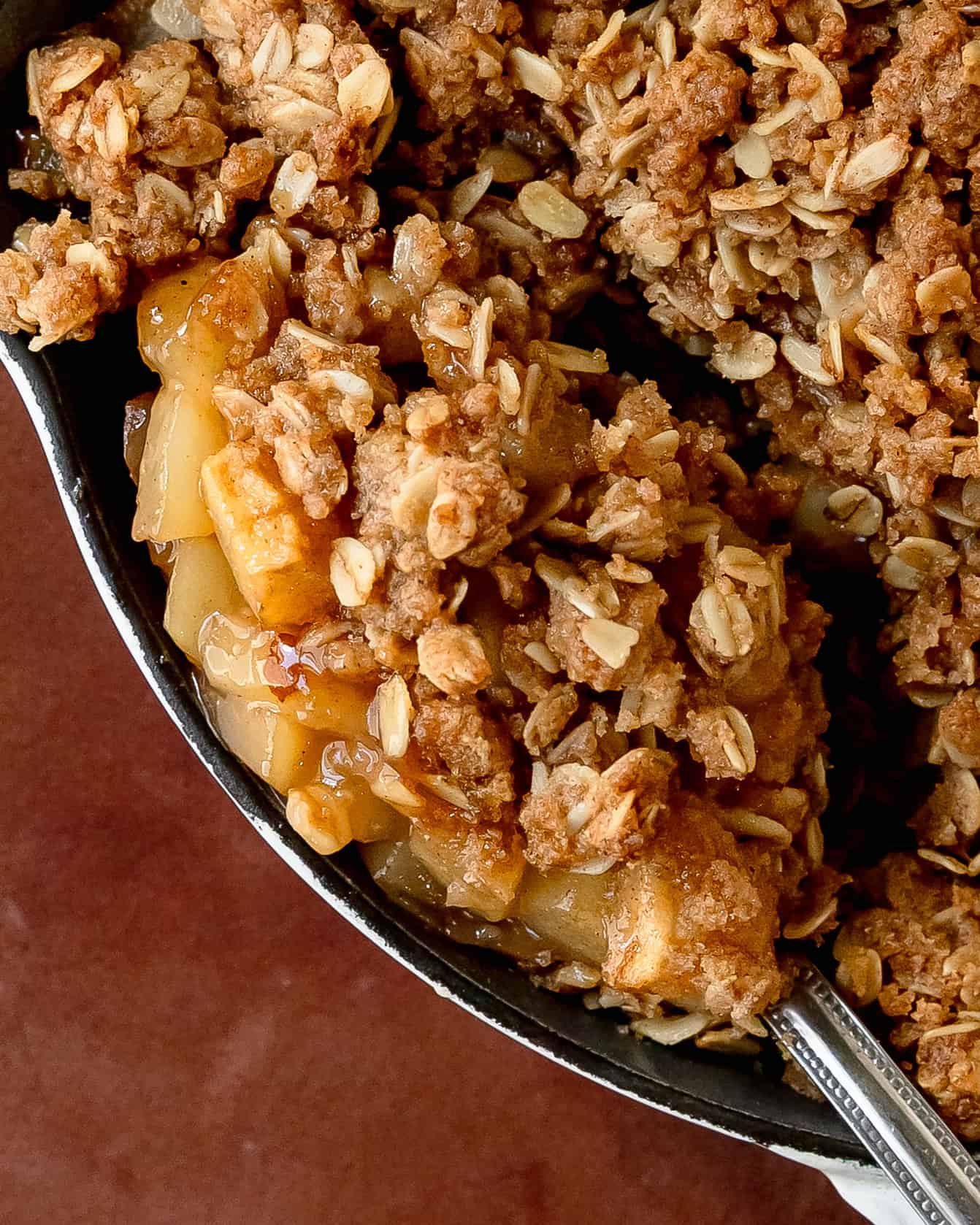 Spoonful of pear crisp showing tender baked pears and oat topping.