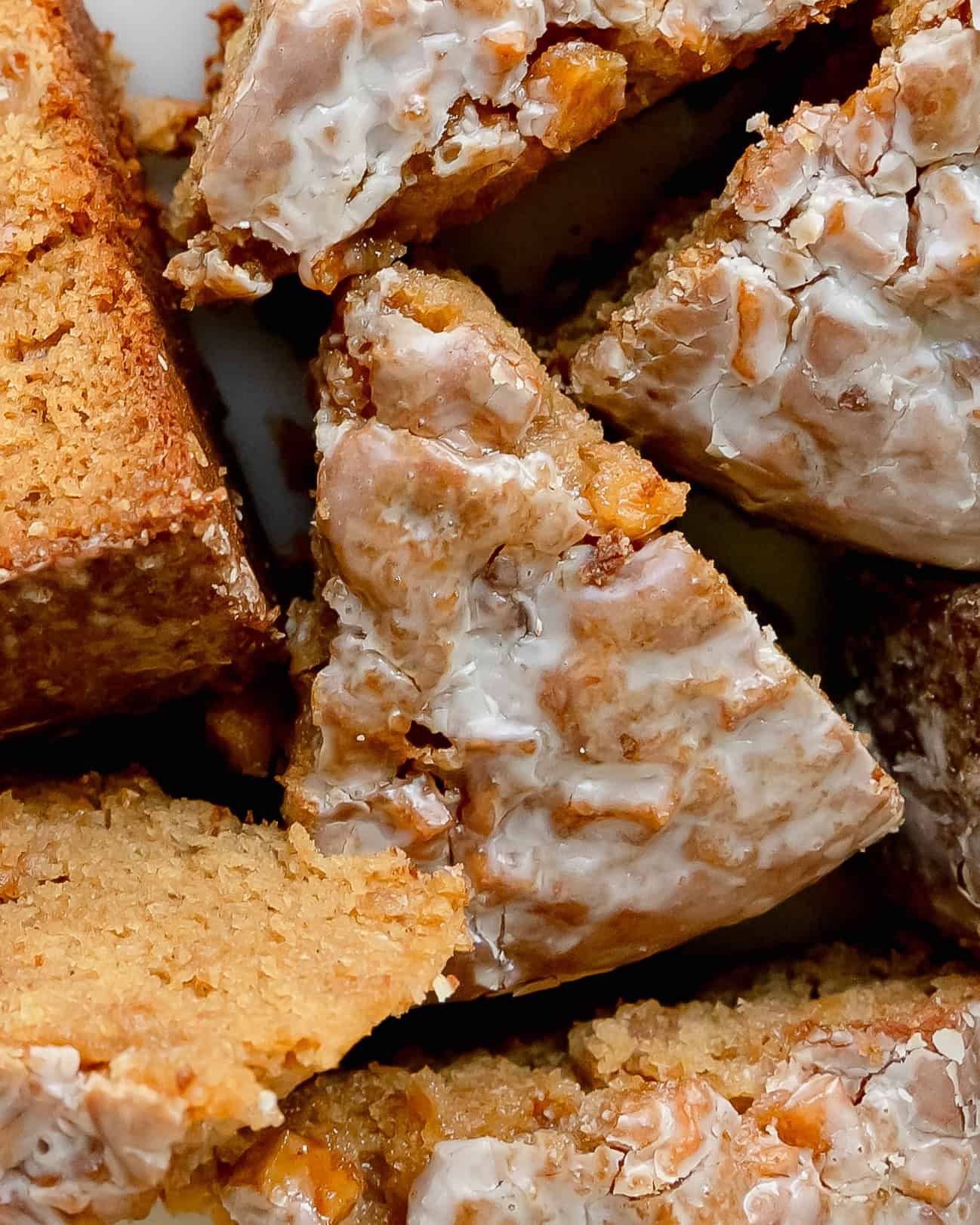 Warm slices of apple fritter cake with cinnamon apples and creamy glaze.