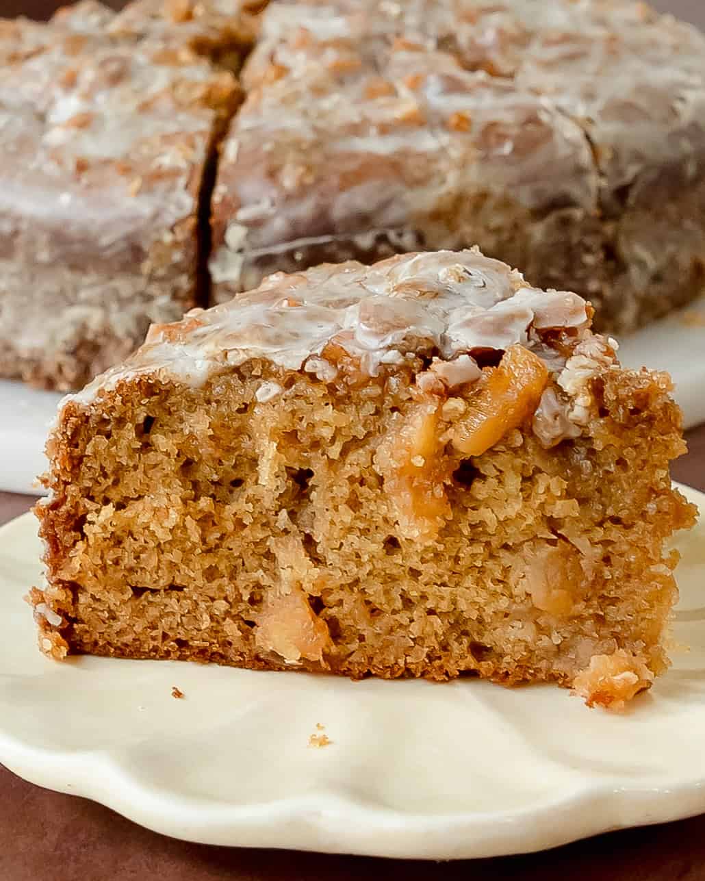 Soft apple fritter cake with juicy apples and cinnamon, topped with a creamy glaze.