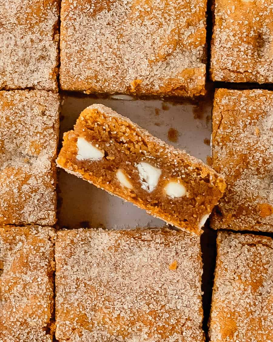 Slice of pumpkin blondies bar facing up to show the chewy texture while the sugary tops are also showing.