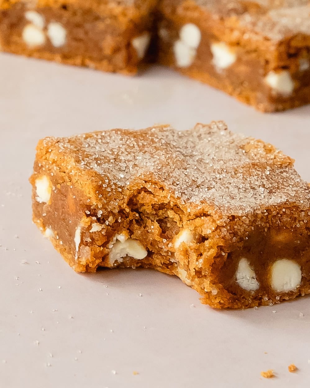 Pumpkin blondie squares with a bite out of it to show the chewy texture.