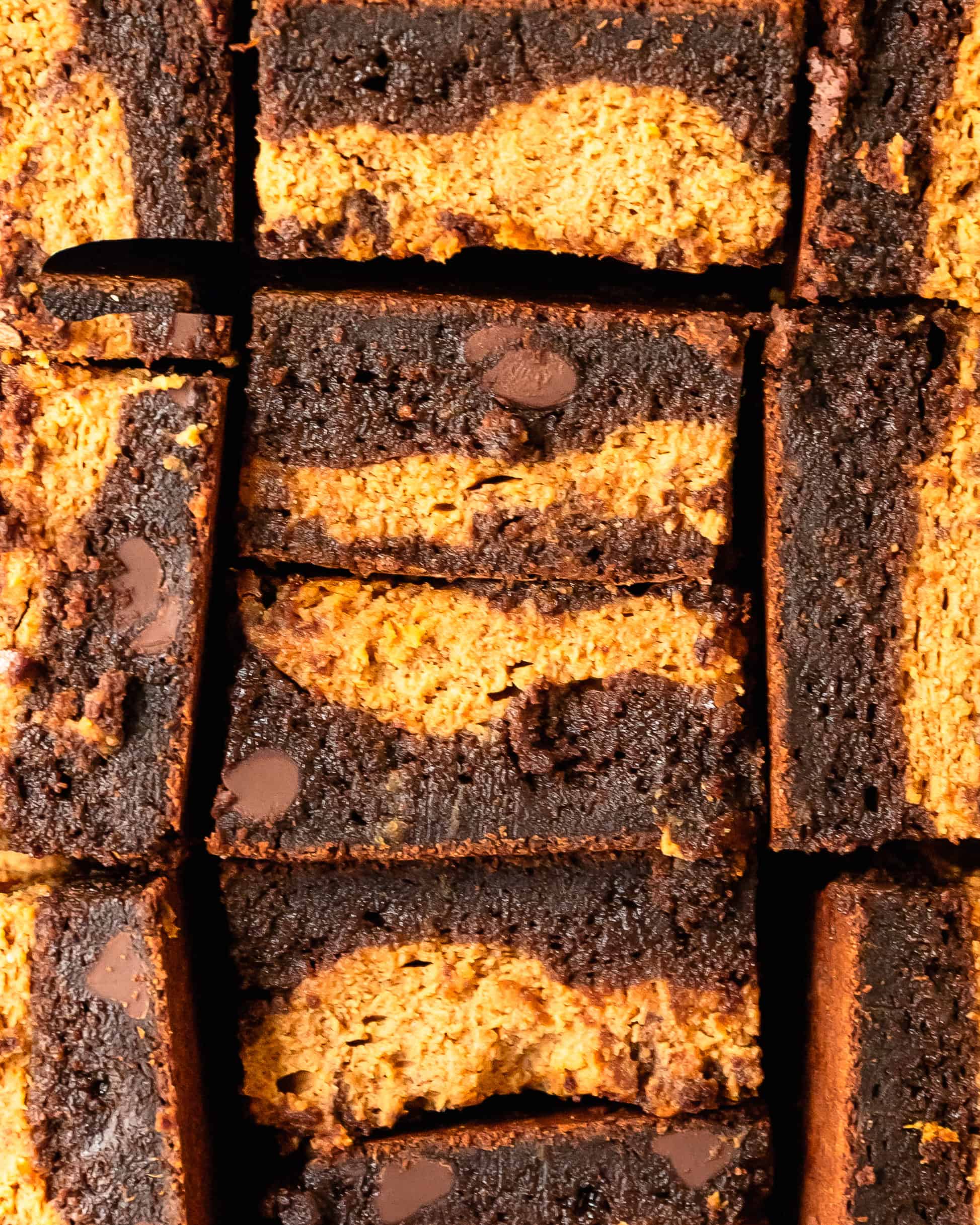 Slices of fudgy pumpkin brownie with a soft chocolate center and swirls of pumpkin.