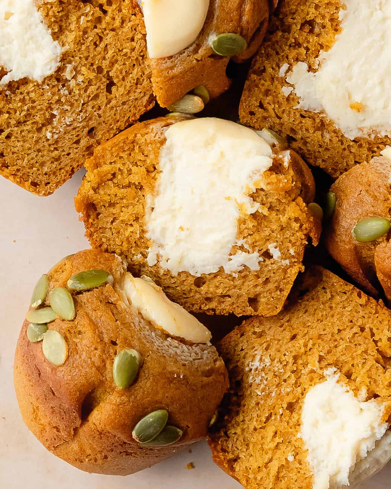 Pumpkin muffin cut open to show the sweet cream cheese filling.