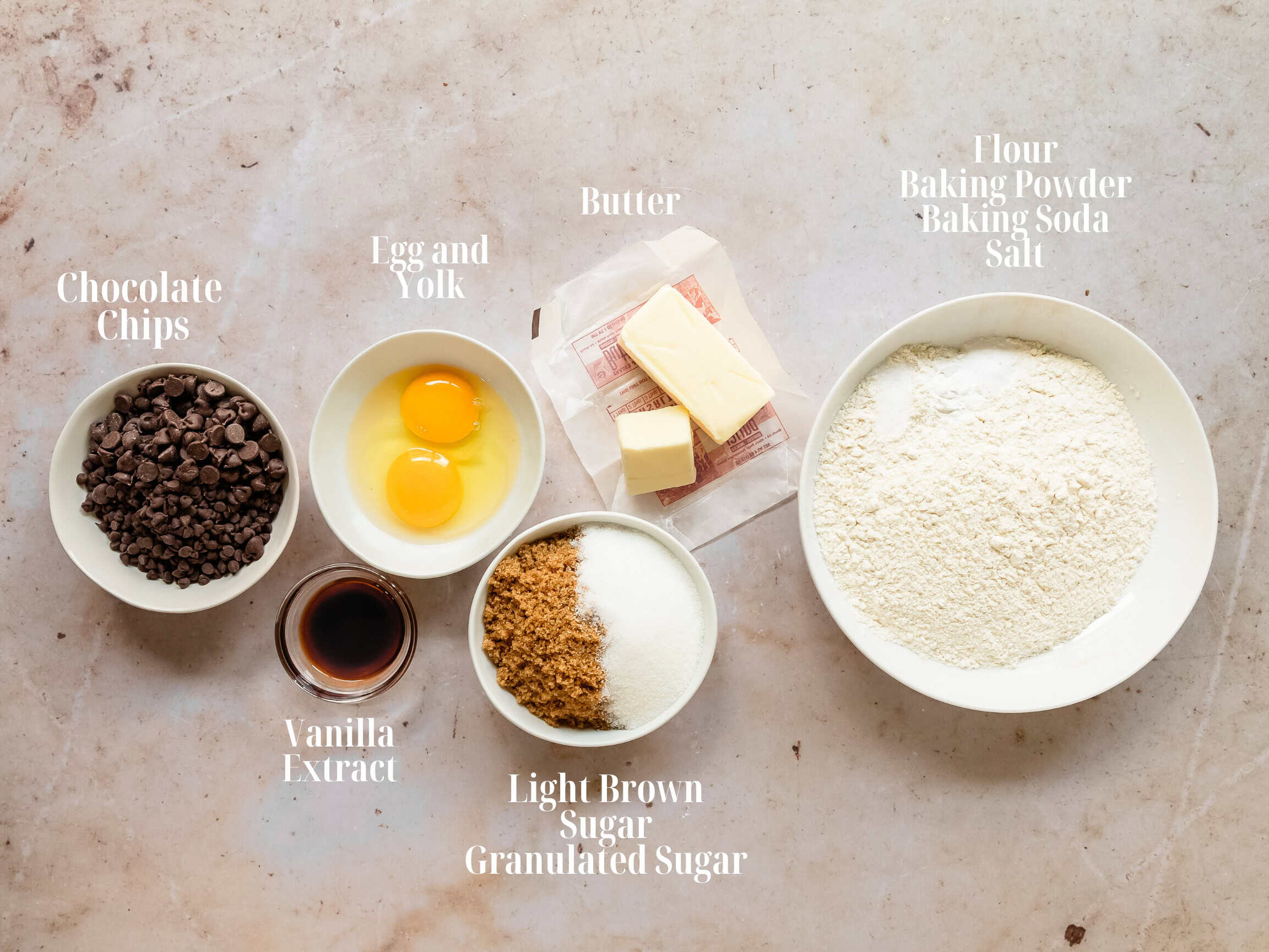 Ingredients to make a chocolate chip skillet cookie in bowls.